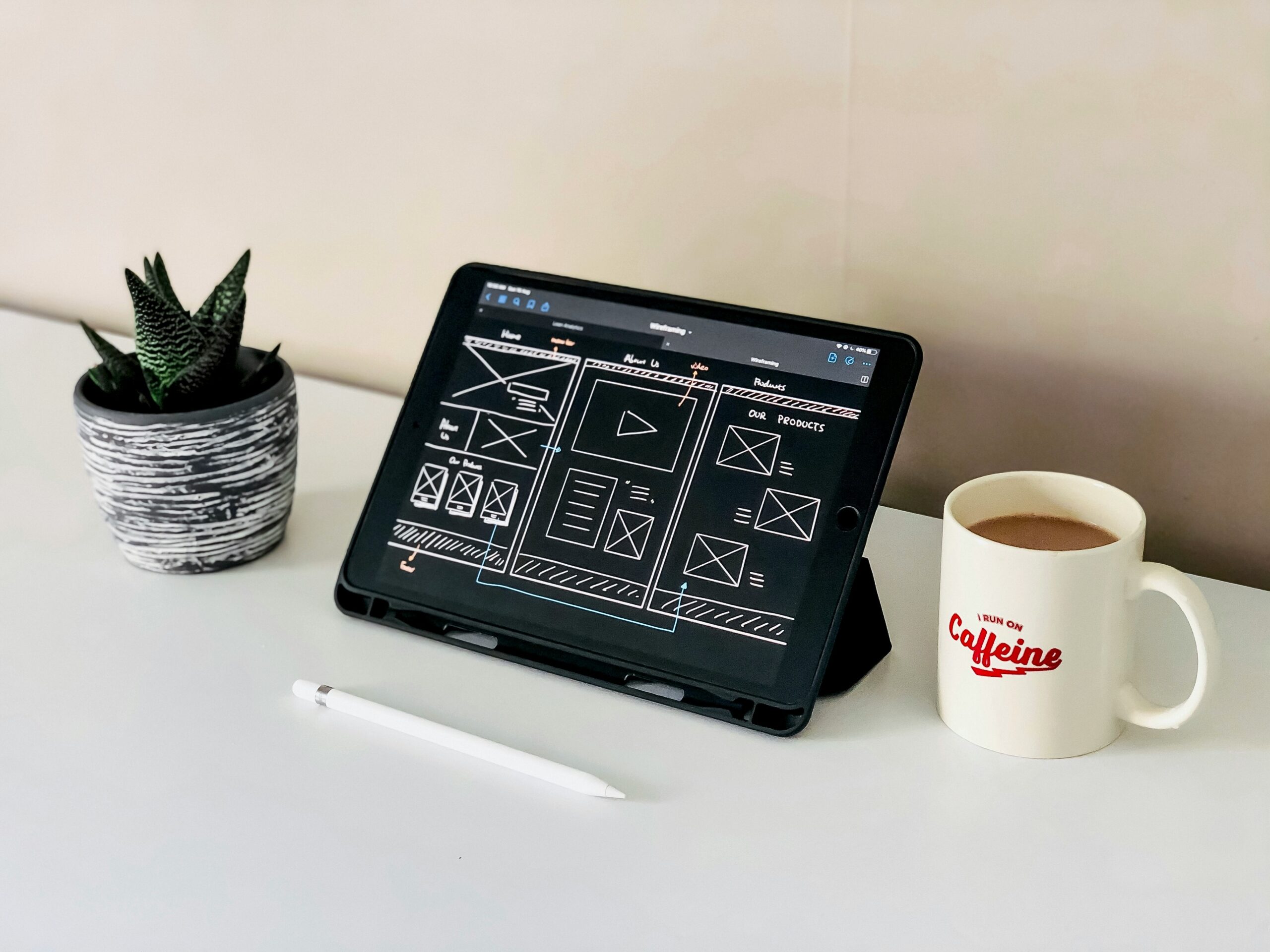 black ipad beside white ceramic mug on white table showing a beginner website builder for a small business