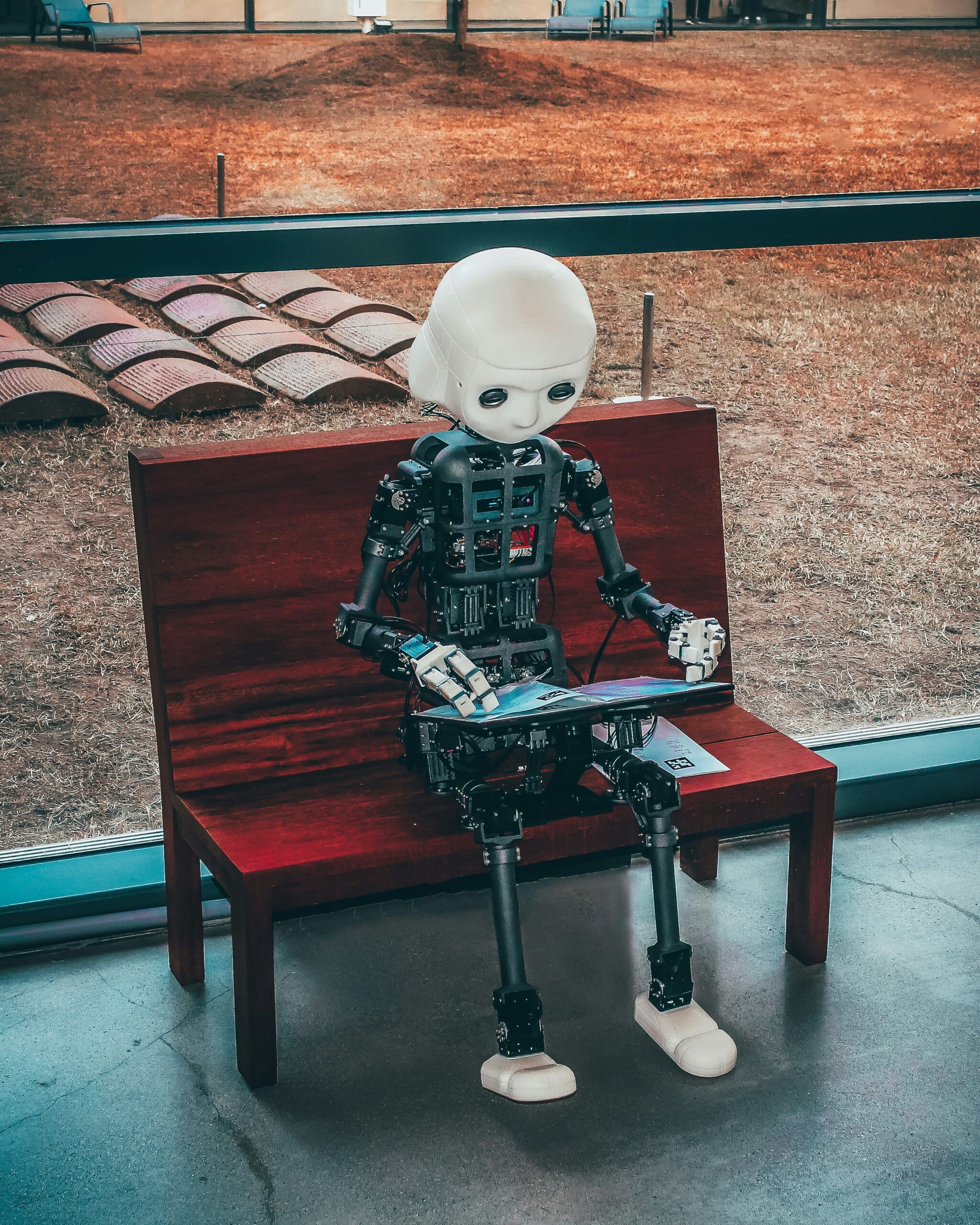black and white robot toy on red wooden table. how to use ai for small business