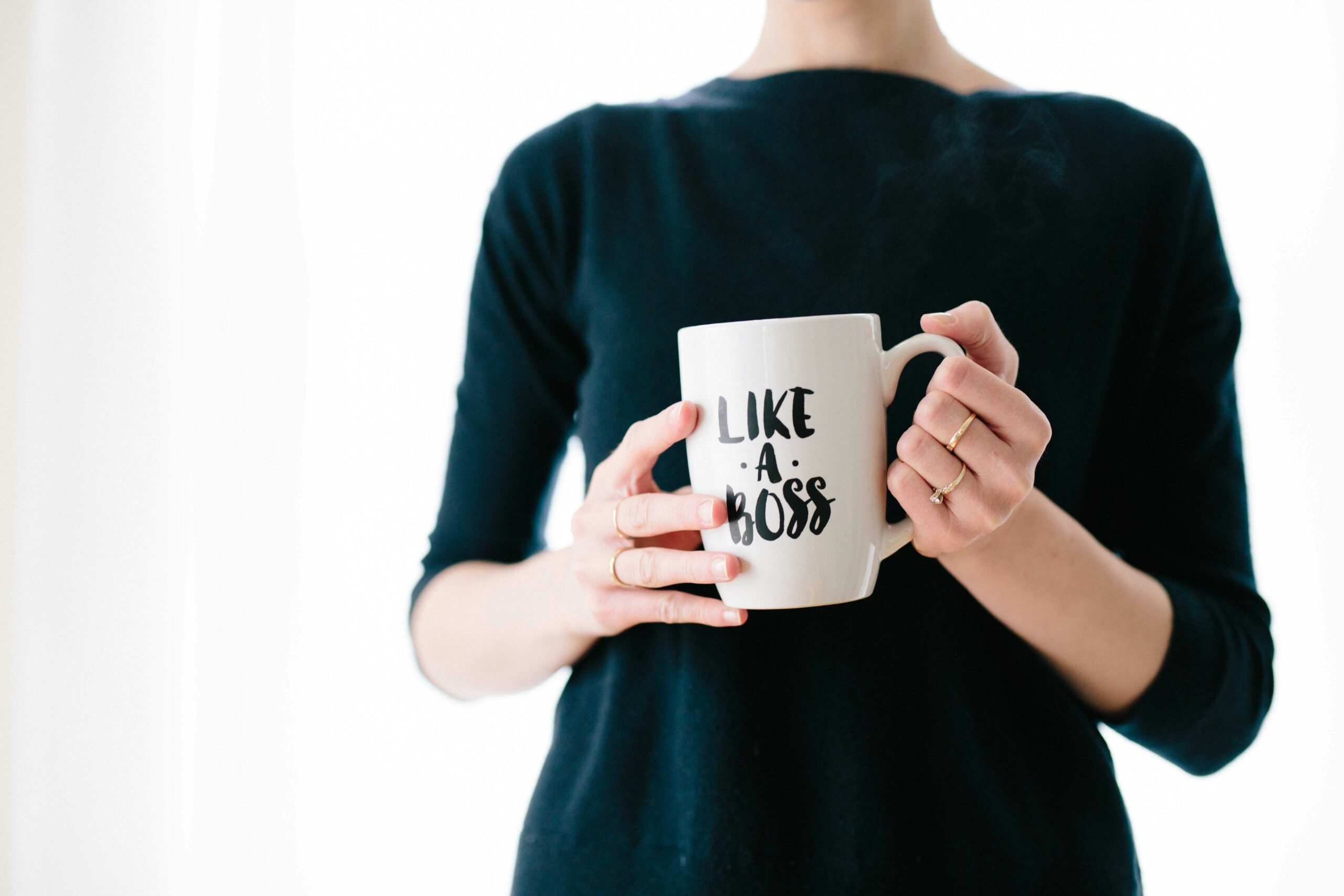 woman holding white mug while standing. Professional Email Address for Small Business
